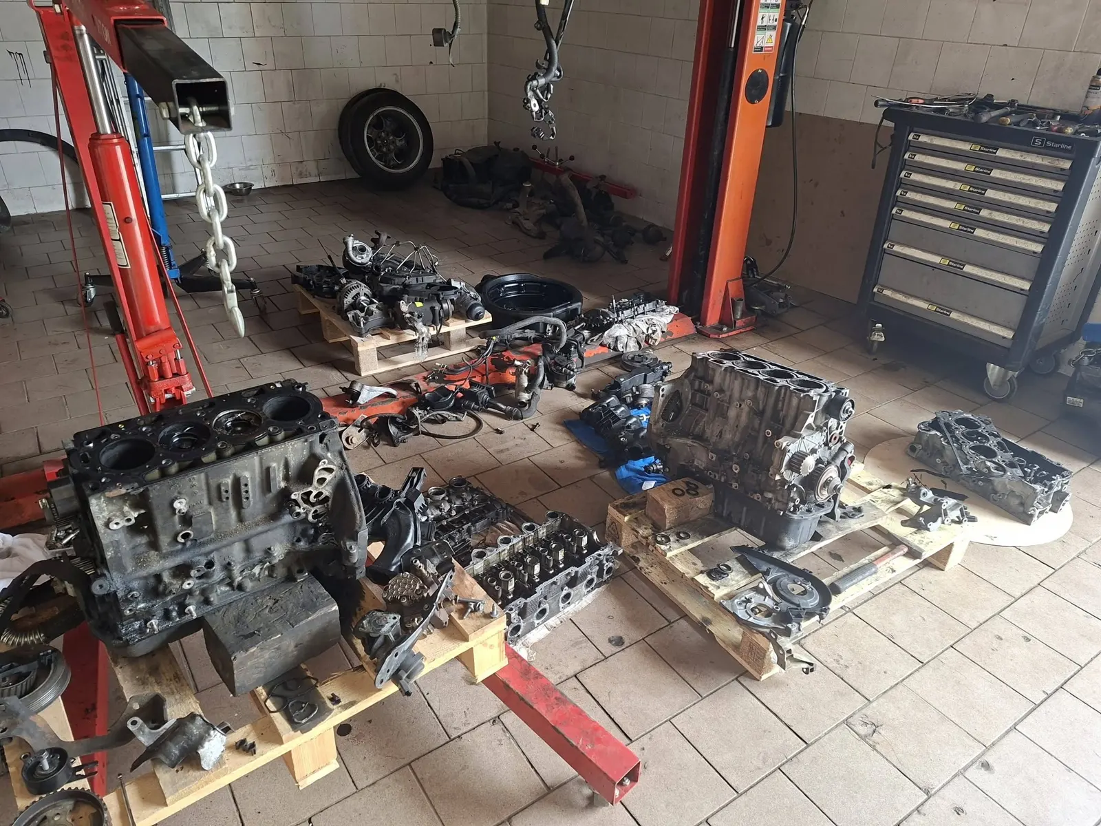 Rozobraté motory a hlavy valcov na paletách v dielni